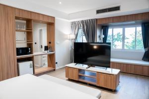 een hotelkamer met een flatscreen-tv en een bed bij Sirin Hotel & Resident in Khon Kaen