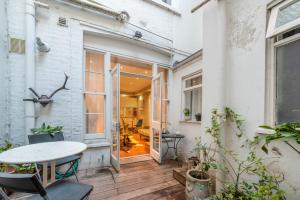 an outdoor patio with a table and a window at Paddington Apartment By Morethanstays in London