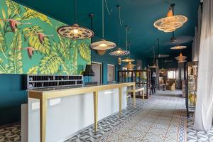 a bar in a restaurant with a tropical wallpaper at Dina Morgabine Saint Gilles in La Saline les Bains