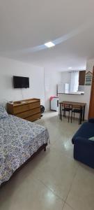 a living room with a bed and a table at Apartamento Extensão do Bosque in Rio das Ostras