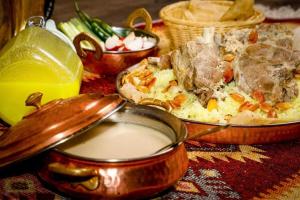 a table with two dishes of food and a bowl of milk at L goats house in Wadi Musa