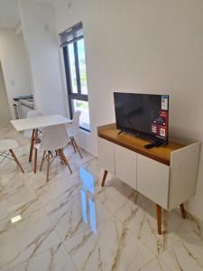 a living room with a tv and a table and chairs at Crisálias Apartamento in Foz do Iguaçu