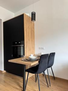 a dining room with a wooden table and chairs at Apartment between the bridges in Zgorzelec
