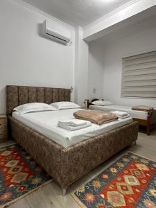 a bedroom with a large bed and a rug at Lola's Rooms in Gjirokastër
