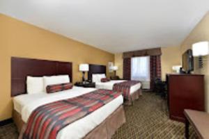 a hotel room with two beds and a television at Baymont by Wyndham Ardmore I-35 in Ardmore +21 photos