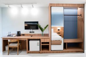 een slaapkamer met een bureau en een spiegel bij Sirin Hotel & Resident in Khon Kaen +80 foto's