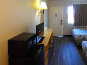 a hotel room with a television and a bed at Motel 6 Ontario, OR in Ontario