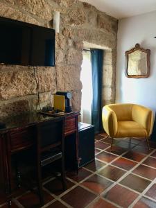 a living room with a desk and a yellow chair at The Hideaway at Quinta de Moçamedes - Suites & Apartments in Vouzela