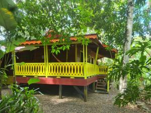 een geel huis midden in een bos bij El Jardin de Playa Negra in Puerto Viejo
