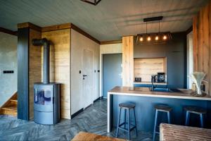 a kitchen with a bar with stools and a stove at Pod Wawrzką in Ropa