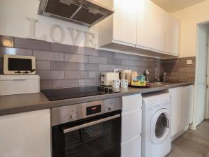 una cocina con lavadora y secadora en una encimera en 10 Bay View Court, en Lyme Regis 17 fotos más
