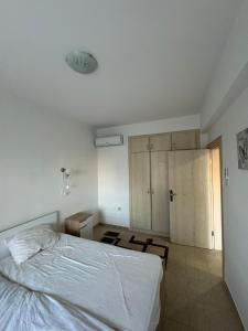 ein Schlafzimmer mit einem weißen Bett und einem Schrank in der Unterkunft 1 Bedroom Apartment Long Beach İskele in Saint Yeorgios + 8 Fotos