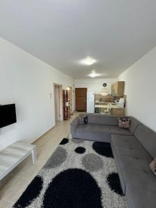 ein Wohnzimmer mit einer Couch und einem Teppich in der Unterkunft 1 Bedroom Apartment Long Beach İskele in Saint Yeorgios