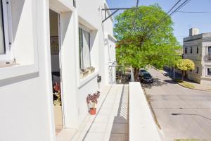 a street view of a white building at Las Blanquitas- departamentos en el casco histórico de Chascomús, a pocos metros de la laguna in Chascomús