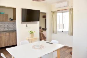a kitchen and dining room with a white table and chairs at Las Blanquitas- departamentos en el casco histórico de Chascomús, a pocos metros de la laguna in Chascomús