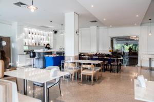 een restaurant met tafels en stoelen en een bar bij Sirin Hotel & Resident in Khon Kaen