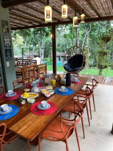 a wooden table with chairs and food on it at CASA PRAIA DO FORTE in Mata de Sao Joao