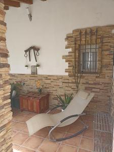 a living room with a stone wall and a chair at Ala Pa cá in Miajadas