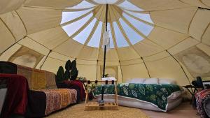 a large tent with a couch and a chair in a room at El Mirador Family Glamping in Estancia de Itargua