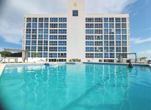 普拉亚科罗纳多5 min de la playa - Cómoda suite con piscina的两栋建筑前的游泳池