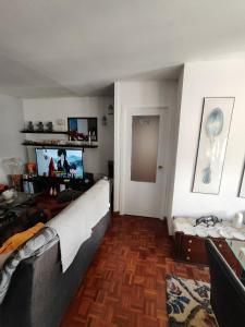 a living room with a couch and a television at Habitación para estancia Agradable in Porriño