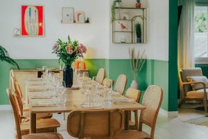 a dining room with a table with glasses and flowers at Maison Élanore - 12 pers - proche Saint-Malo in Pleurtuit