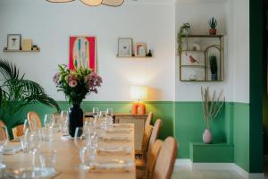 a dining room with a table with glasses and flowers at Maison Élanore - 12 pers - proche Saint-Malo in Pleurtuit