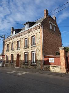 an old brick building on the side of a street at chez Marie et Patrick in Chaulnes