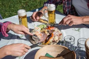 a group of people sitting at a table with beer at Guggenthaler Gipfelblick in Guggenthal
