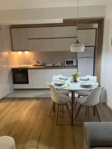 a kitchen with a white table and chairs in a room at Skopje-Modern, home apartment-Kozle in Ždanec