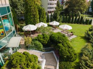 an overhead view of a garden with tables and umbrellas at Hotel Artur in Kraków +85 photos
