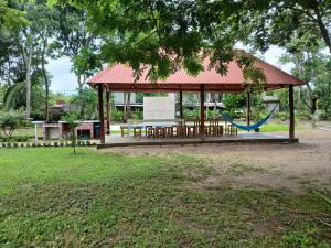 a park with a gazebo with a blue swing at Garden Suites Comalcalco in Comalcalco