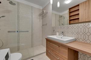 łazienka z umywalką i prysznicem w obiekcie Grand Apartments · Okrzei Residence w mieście Sopot +37 zdjęć