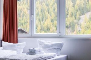 a bedroom with two beds and a large window at International House Sölden Studio mit Bergblick ZW 1 in Sölden
