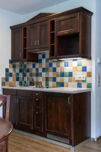a kitchen with wooden cabinets and tiles on the wall at International House Sölden Studio mit Bergblick ZW 1 in Sölden +6 photos