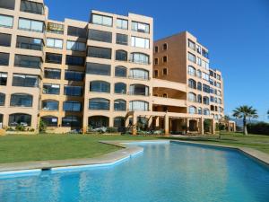 拉塞雷纳gran departamento para 11 personas en cuatro esquinas的一栋建筑前有一座游泳池