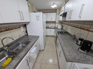 拉塞雷纳gran departamento para 11 personas en cuatro esquinas的一个小厨房，里面有水槽和冰箱