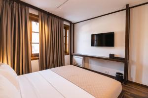 a hotel room with a bed and a flat screen tv at N'SOKAK Boutique Hotel in Gjirokastër
