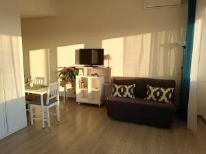 a living room with a couch and a table at Mare e Relax 1 Melody Sea Front 10' da FCO Airport in Fiumicino +7 photos