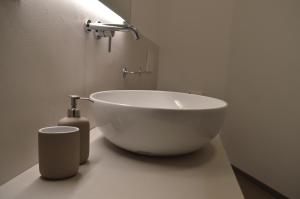 une salle de bain avec un lavabo blanc et une bouteille de savon dans l'établissement Casa Mezzofanti, à Bologne
