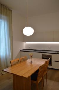 une table à manger avec des chaises et un vase de fleurs. dans l'établissement Casa Mezzofanti, à Bologne