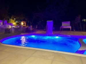 a swimming pool lit up at night with purple lights at Flats Macapá Meu Amor 11 in Luis Correia