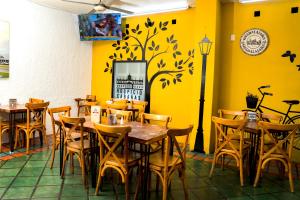 a restaurant with tables and chairs and a yellow wall at Hotel Arboledas Expo in Guadalajara