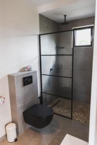 baño con aseo negro en una habitación en Villa Blenchi, en Willemstad 15 fotos más