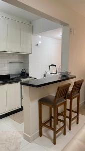 a kitchen with two chairs and a counter with a sink at Apartamento na praia, quadra do mar, Rua novo píer in Itapema +14 photos