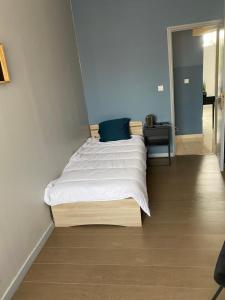 una camera da letto con un letto grande con lenzuola bianche di Appartement 2 chambre roubaix a Roubaix