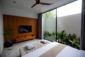 a bedroom with a large bed and a large window at Rahya Villas Complex by Iji in Uluwatu +125 photos