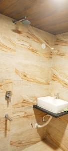 a bathroom with a sink on a wooden wall at Baga Sea Link in Baga +35 photos