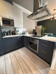a kitchen with black cabinets and a wooden floor at Stunning 2-bedroom Apartment in Manchester Centre in Manchester