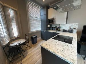 a kitchen with a counter and a table and chairs at Stunning 2-bedroom Apartment in Manchester Centre in Manchester +6 photos